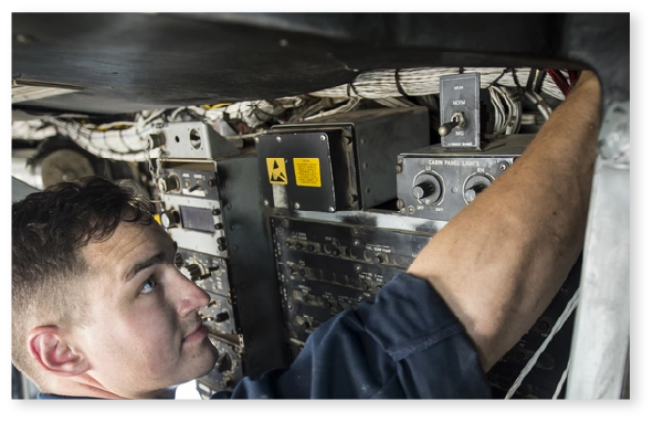 Image of a young man performing maintenance work on a helicopter